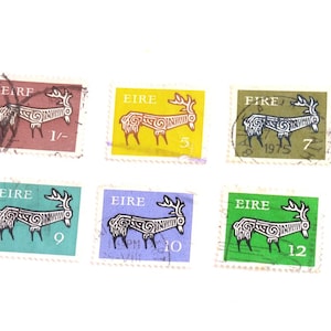 Può includere: Una collezione di sei francobolli rettangolari provenienti dall'Eire, ognuno dei quali presenta un'illustrazione stilizzata di un cervo nero. I francobolli sono di vari colori, tra cui rosso, giallo, oliva, verde acqua, viola e verde, con valori numerici e il testo EIRE.