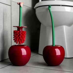 Op de afbeelding: Een toiletborstel en houder set in de vorm van een kers. De houder is glanzend rood, met een groene steel. De borstel is rood en de steel is groen. Een leuke badkameraccessoire.