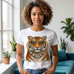 Könnte beinhalten: Ein weißes Kurzarm-T-Shirt mit einer grafischen Illustration eines Tigers, der eine Brille mit Leopardenmuster und eine große, facettierte Kristall-Statement-Halskette trägt. Der Tiger ist in Orange-, Schwarz- und Weißtönen dargestellt.