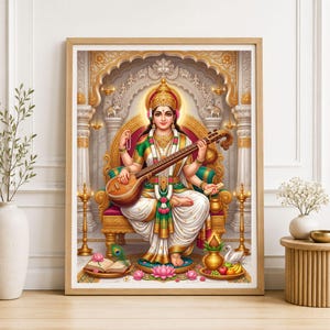 Könnte beinhalten: Ein gerahmter Wandkunstdruck, der die hinduistische Göttin Saraswati auf einem verzierten goldenen Thron sitzend zeigt. Sie trägt einen weiß-grünen Sari, hält eine Veena und ist von traditionellen Elementen wie einem Buch, Lotusblumen und einem Schwan umgeben.