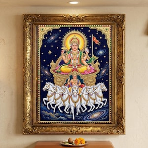 May include: A framed wall art print featuring a deity seated on a golden chariot pulled by seven white horses against a dark blue cosmic background with stars and galaxies. The ornate gold frame surrounds the rectangular artwork with detailed borders.