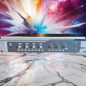 May include: A gray audio mixer with multiple knobs and input jacks. The mixer has a series of buttons and a power button. The background is a colorful, abstract design with shades of blue, purple, and orange.