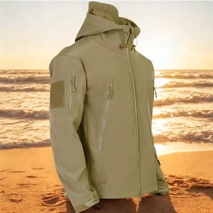 May include: Khaki-coloured hooded jacket with several zipped pockets and a patch on the left sleeve. The jacket features a full-length zip and a drawstring hood. The background shows a beach scene with the sun setting over the ocean.