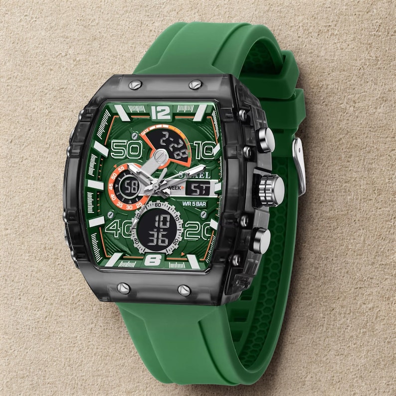 K&ouml;nnte beinhalten: Eine gr&uuml;ne und schwarze digitale Armbanduhr mit einem gr&uuml;nen Silikonarmband. Das Zifferblatt ist gr&uuml;n mit wei&szlig;en und orangefarbenen Akzenten und zeigt die Uhrzeit und das Datum an. Die Uhr hat mehrere Kn&ouml;pfe und eine Edelstahlschnalle.