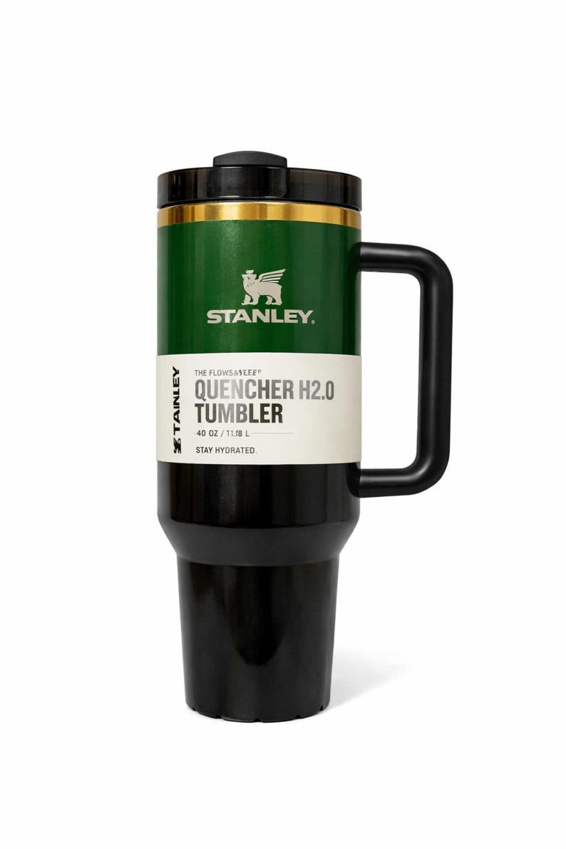 May include: A green and black Stanley Quencher H2.0 Tumbler with a black handle. The tumbler has a black lid and a gold band. The text on the tumbler reads "QUENCHER H2.0 TUMBLER" and "STAY HYDRATED". It holds 40 oz.