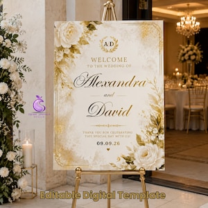 Könnte beinhalten: Ein rechteckiges Hochzeits-Willkommensschild auf einer goldenen Staffelei mit cremefarbenem Hintergrund und goldenen sowie weißen Blumenakzenten. Der Text lautet: AD, WELCOME TO THE WEDDING OF Alexandra and David, THANK YOU FOR CELEBRATING THIS SPECIAL DAY WITH US! 09.09.26.