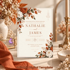 May include: A rectangular wedding invitation template featuring a cream background with rust-orange and white floral arrangements in the corners. The text reads: Two lives one beautiful journey, Nathalie and James, August 24, 2026, The Garden Valley Estate.