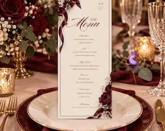 May include: A vertical wedding menu card on cream cardstock featuring dark burgundy rose illustrations, white baby's breath, and a deep red ribbon accent. The text includes sections for appetizers, soups, main dishes, desserts, and beverages.