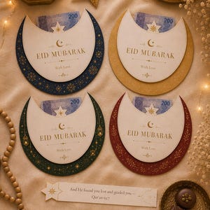 May include: Four crescent-shaped Eid Mubarak cards in navy, gold, green, and burgundy, each holding a bill. The cards feature gold text and star and moon designs. Decorative elements include a star, a lantern, and a small dish with chocolates.