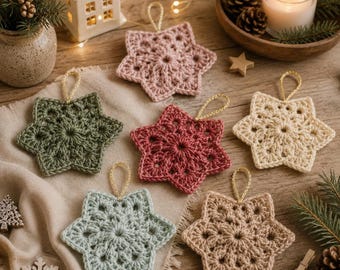 May include: Six crocheted star ornaments in various colors including sage green, dusty rose, deep red, cream, light blue, and beige. Each star features a central circular pattern with radiating points and a gold hanging loop attached to the top.