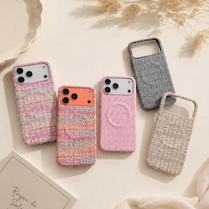 Peut inclure: Plusieurs coques de téléphone aux couleurs variées, notamment rose, gris et beige, avec une texture tissée. L'une des coques présente un motif circulaire. Un carnet avec l'inscription "Rayon de Soleil" est également visible.