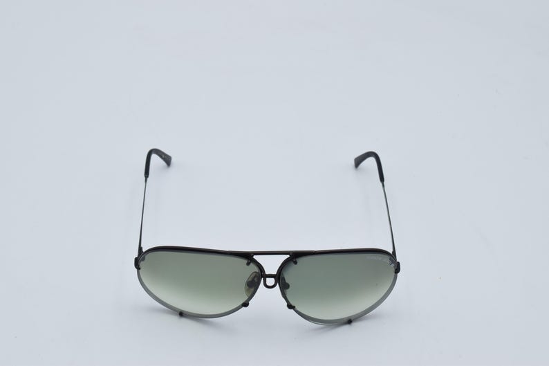 K&ouml;nnte beinhalten: Schwarze Aviator-Sonnenbrille mit d&uuml;nnem Metallrahmen und Farbverlaufsgl&auml;sern. Die Sonnenbrille hat einen Doppelsteg und gebogene B&uuml;gel. Die Gl&auml;ser gehen von einem dunkleren Farbton oben zu einem helleren Farbton unten &uuml;ber.