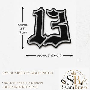 May include: An embroidered patch featuring the number 13 in a black gothic font with a white border. The patch measures approximately 2.8 inches in height and 3 inches in width. The design includes a detailed stitched finish and an iron-on backing.