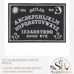 May include: A rectangular black embroidered patch featuring a white Ouija board design. The patch includes the alphabet, numbers 0-9, the words YES, NO, OUIJA, and GOOD BYE, along with sun, moon, and star symbols. It measures 3.6 inches in width.