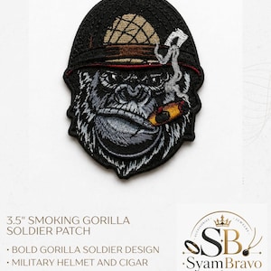May include: An embroidered patch measuring 3.5 inches featuring a gorilla wearing a tan military helmet and smoking a cigar. The design includes black, grey, tan, and red thread details with white smoke rising from the cigar against a black background.