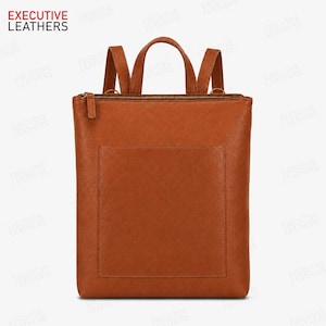Könnte beinhalten: Ein hellbrauner Lederrucksack mit rechteckiger Silhouette, einer großen Vordertasche, einem Reißverschluss an der Oberseite und zwei Schultergurten. Der Markenname EXECUTIVE LEATHERS ist oben links im Bild aufgedruckt.