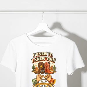 May include: A white short-sleeved t-shirt featuring a graphic print of two cowboy boots, a desert landscape with cacti, and two hands performing a pinky promise. The text reads I KNEW IT, I KNEW YOU! and BEST FRIENDS FOREVER with a horseshoe.