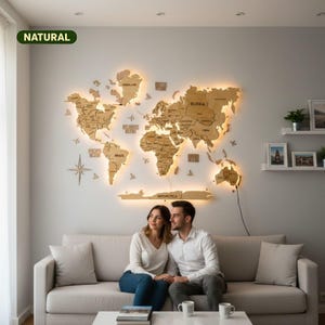 Op de afbeelding: Een grote wereldkaart van natuurlijk hout als wanddecoratie, voorzien van lasergesneden continenten en landen met gegraveerde labels. De kaart is voorzien van warme LED-achtergrondverlichting, wat een gloeiend effect op de muur geeft.