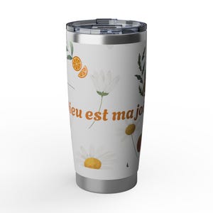 Peut inclure: Un gobelet en acier inoxydable avec un couvercle en plastique transparent, orné d'un motif de tranches d'orange, de feuilles vertes et de marguerites blanches sur fond blanc. Le texte "Dieu est ma joie" est inscrit en lettres orange.