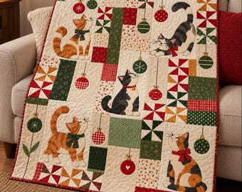 May include: A quilted throw blanket featuring a cream background with a patchwork design of red and green geometric patterns. The quilt displays five illustrated cats in various poses, accented by hanging Christmas ornament motifs.