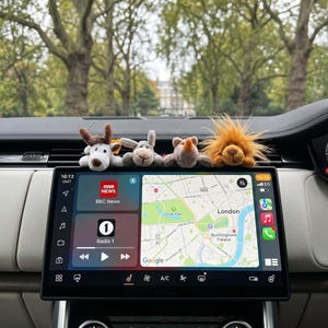 Könnte beinhalten: Ein Auto-Armaturenbrett mit vier kleinen Plüschtierfiguren: ein Reh, ein Hase, ein Nashorn und ein Löwe. Der Bildschirm zeigt eine Karte von London, BBC News und Radio 1.