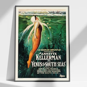 May include: A framed vintage movie poster for Venus of the South Seas featuring Annette Kellerman. The artwork depicts a figure in an orange swimsuit swimming underwater in deep green water with white text reading Lee Bradford Corporation presents.