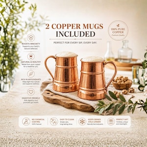 Könnte beinhalten: Zwei Kupferbecher mit metallischem Glanz und Henkeln, gefüllt mit Schaum. Der Text auf dem Bild enthält 2 COPPER MUGS INCLUDED, 100% PURE COPPER, sowie Vorteile wie BOOSTS IMMUNITY, NATURAL & HEALTHY, RICH IN ANTIOXIDANTS und DIGESTIVE FRIENDLY.