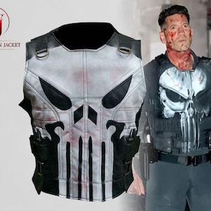 Op de afbeelding: Een grijs en zwart tactisch vest met een schedelontwerp, met zwarte zakken en riemen. Het vest wordt gedragen door een persoon op de afbeelding. Het Washington Jacket-logo staat in de linkerbovenhoek.