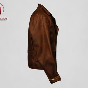 Pu&ograve; includere: Giacca in pelle marrone dal design classico. La giacca presenta un colletto, tasche e un polsino con bottoni. Il logo "WASHINGTON JACKET" &egrave; visibile sul lato sinistro. La giacca &egrave; realizzata in pelle marrone.