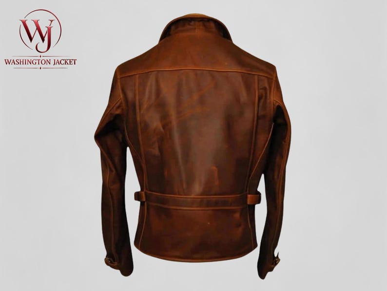 Pu&ograve; includere: Giacca in pelle marrone con colletto, maniche lunghe e dettaglio cintura in vita. La giacca ha un design classico ed &egrave; realizzata in pelle invecchiata. Il logo "Washington Jacket" &egrave; visibile nell'angolo in alto a sinistra.