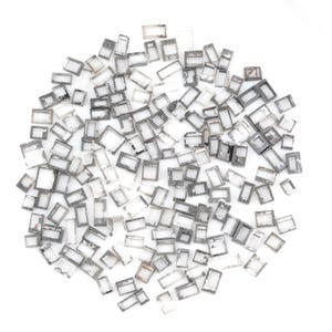 May include: A collection of numerous small, rectangular, metallic-coloured frames scattered in a circular arrangement. Each individual piece features a hollow centre and a thin, flat border with a slightly weathered, dark grey, and silver finish.