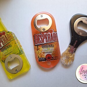 Pu&ograve; includere: Tre apribottiglie con top in metallo. Uno &egrave; giallo e a forma di bottiglia di birra con il testo "DESPERADOS ORIGINAL BIERE-BIER". Un altro &egrave; arancione con lo stesso testo. Il terzo &egrave; nero con scaglie d'oro.