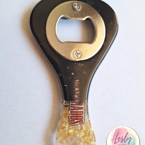 Pu&ograve; includere: Apribottiglie nero e oro con apri argento. Il manico &egrave; nero con scaglie d'oro e il testo "RAPIDOS" in rosso e bianco. Un accessorio da bar unico.