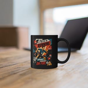 May include: Black ceramic mug with a humorous graphic. The mug features a retro-style illustration of a person running with the text "If you see me running, equipment probably on fire."