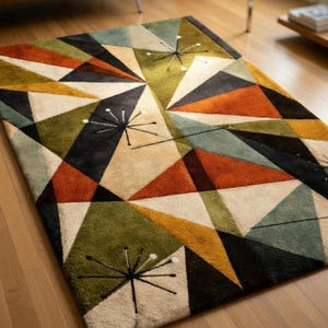 May include: A rectangular area rug featuring a geometric pattern of triangles in shades of olive green, burnt orange, mustard yellow, black, and cream. The design includes black starburst motifs with white dots at the ends of the thin lines.