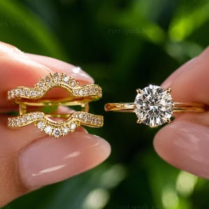 Puede incluir: Un conjunto de anillos de oro amarillo compuesto por un anillo solitario con una piedra central redonda de talla brillante y un anillo protector curvo con una hilera de pequeños diamantes engastados en pavé a lo largo de la banda arqueada.