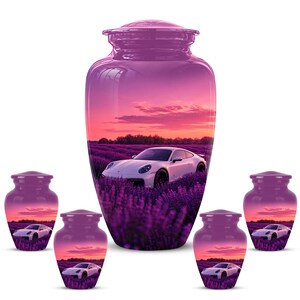 May include: A large central cremation urn and four smaller matching urns, all featuring a glossy purple finish. Each urn displays a printed scene of a white sports car parked in a vibrant purple lavender field under a sunset sky with pink clouds.
