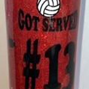 May include: Red glitter water bottle with a black lid. The bottle has the text "YOU JUST GOT SERVED" and the number "13" in black. A volleyball graphic and a basketball graphic are also featured.