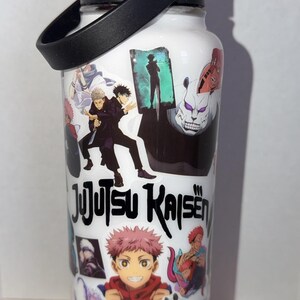 May include: White water bottle featuring colorful anime character graphics and the text "Jujutsu Kaisen." The bottle has a black handle and lid. The bottle is sitting on a blue surface.