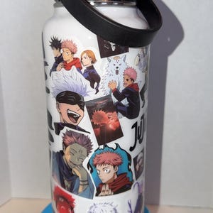 May include: White water bottle featuring anime character illustrations. The bottle has a black lid, a black handle, and a silver accent. The bottle is decorated with various anime character images in different poses and colors.