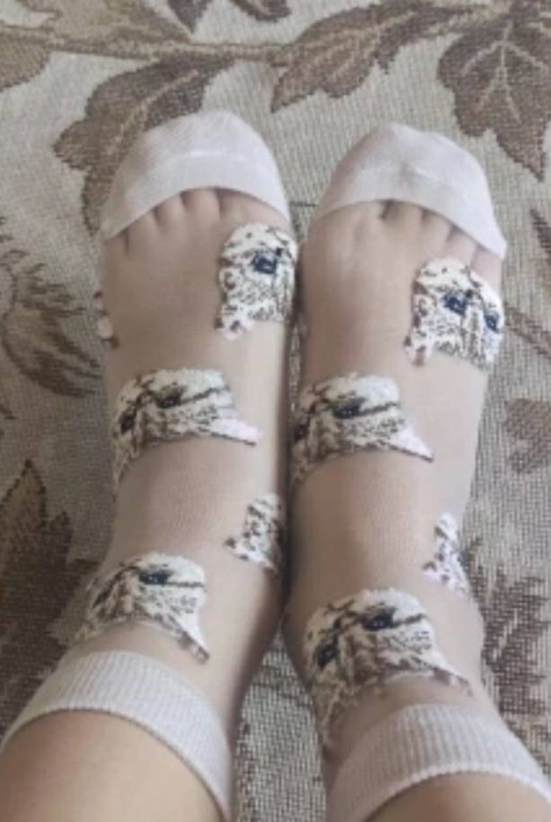 May include: A pair of sheer white socks with a delicate pattern of small white owls. The socks are made of a lightweight, breathable fabric and are perfect for everyday wear.