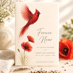 May include: A rectangular memorial seed packet featuring a watercolor illustration of a red cardinal in flight above red poppy flowers. The text reads Forever Near, IN LOVING MEMORY, ROBERT JAMES ANDERSON, MAY 12, 1948 - MARCH 3, 2024, WILDFLOWER SEEDS.