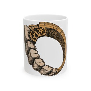 May include: A white ceramic mug featuring a circular illustration of a mechanical device. The design combines a series of human-like teeth on the left side with a tan-colored, gear-driven measuring arc on the right, rendered in black ink.
