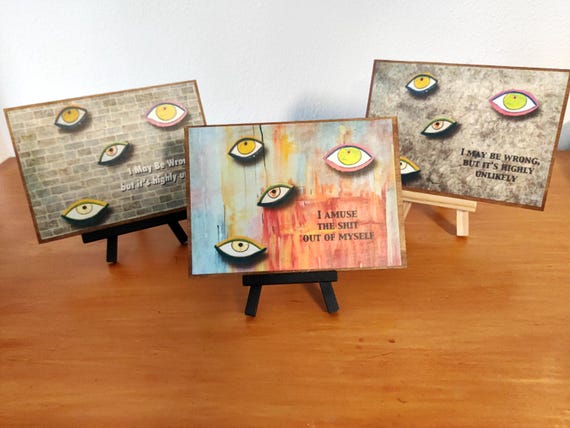 Hand-crafted wooden plaque with a whimsical mixed-media eye design — the kind of offbeat wall art that sparks instant conversation.
