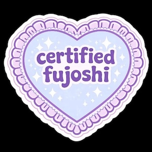 May include: A heart-shaped sticker with a light blue center and a lavender border. The text "certified fujoshi" is written in purple. The sticker has a scalloped edge and small star accents.