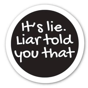 May include: A circular sticker with a black central area and a white border. The text "It's lie. Liar told you that" is written in white, in a handwritten style font.