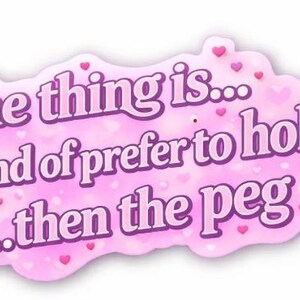 May include: A pink sticker with a cloud-like shape and the text "the thing is... I kind of prefer to hole... then the peg" in purple. Small pink hearts are scattered around the text.