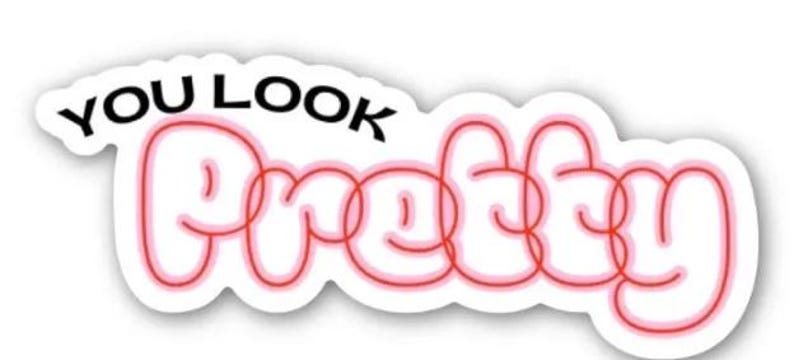 May include: A white sticker featuring the words "YOU LOOK" in black, above the word "Pretty" in a red, bubble-style font with a pink outline. The sticker has a white border.