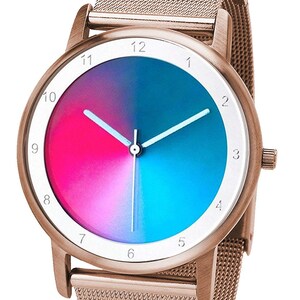 May include: A rose gold wristwatch with a mesh band and a round face. The watch face is divided into two halves, one pink and one blue. White hands and numerals mark the hours.