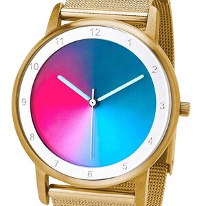 May include: Gold-tone wristwatch with a mesh band. The watch face features a gradient of pink and blue, with white hands and hour markers. The watch has a gold-tone bezel and a textured mesh band.